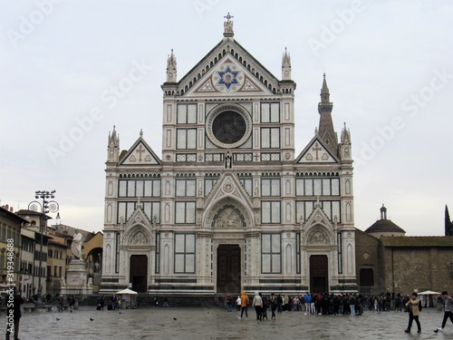 View of the Basilica of Santa Croce in Florence, Italy with tourists at sunset 