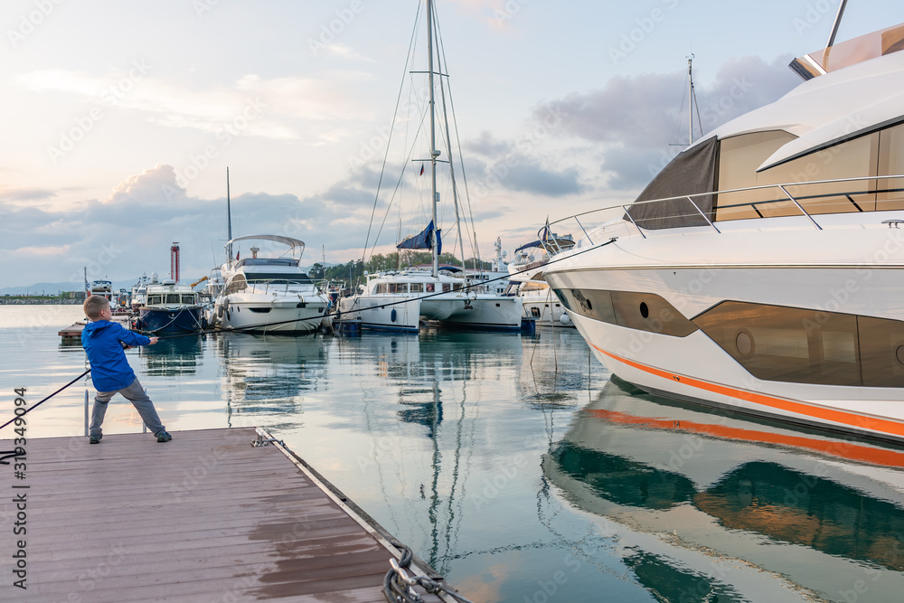 Fototapeta premium Boy Moor A Big Yacht On A Dock.