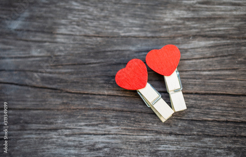 Two red heart wooden clip on wood texture bacground, love and romace symbol, valentine concept background photo