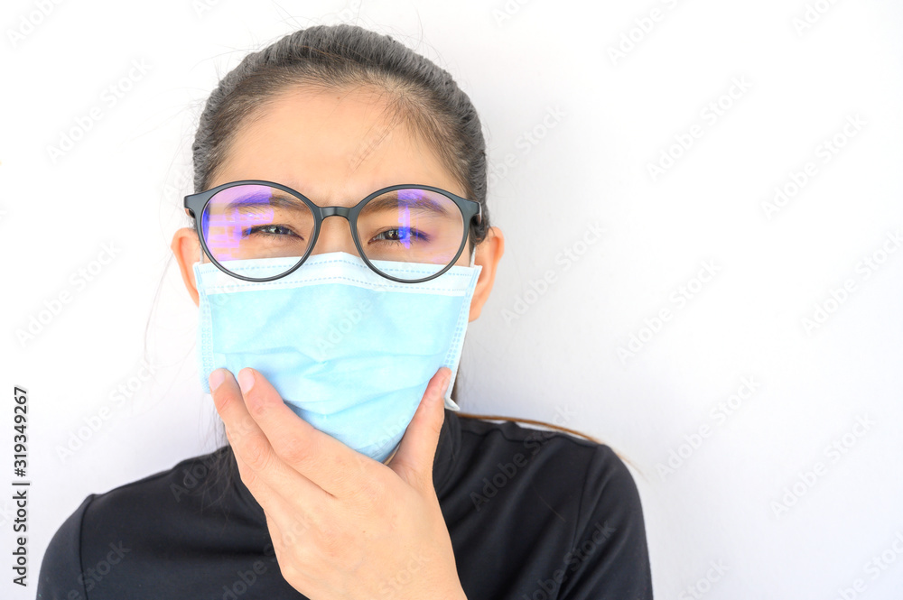 Close up of young Asian woman coughing and wearing mask for protect bad air pollution. Air pollution has been associated with diseases of the heart and lungs, cancers and other health problems. Close up of young Asian woman coughing and wearing mask for protect bad air pollution. Air pollution has been associated with diseases of the heart and lungs, cancers and other health problems.