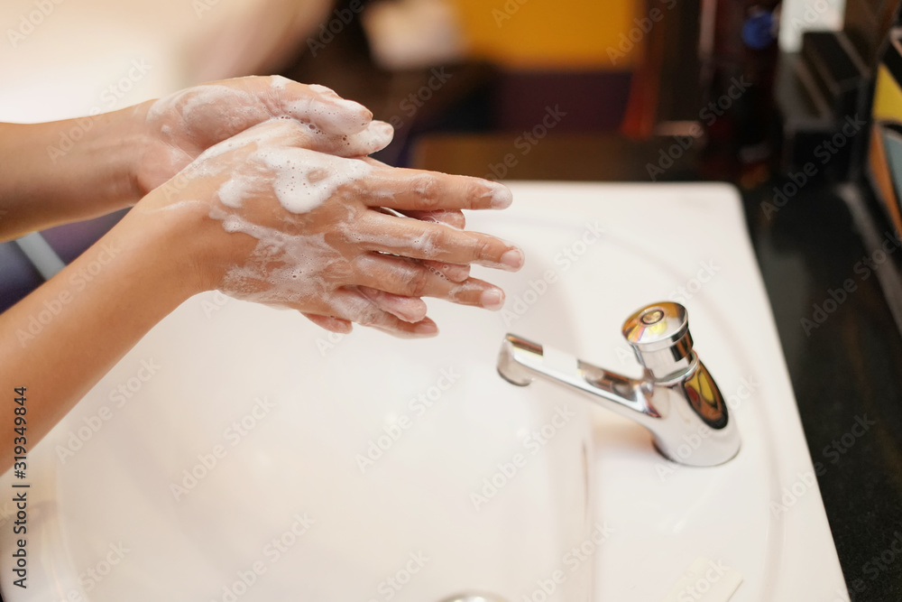 women washing hands with sanitizer soap and water after using a public ...