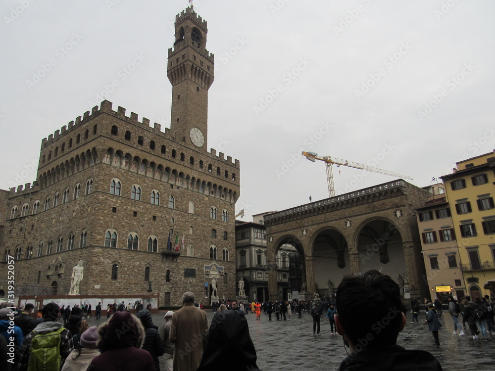 Obraz premium The Palazzo Vecchio which is the town hall of Florence, Italy with Piazza della Signoria crowded with tourists