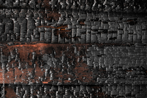 Abstract background with a burned boards texture closeup. Burned scratched hardwood surface. Charred wood plank background. Dark burned wooden texture empty horizontal surface, copy space.