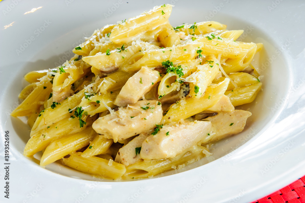 Italian pasta in cheese sauce ,decorated with parsley on a table. Italian pasta in cheese sauce ,decorated with parsley on a table.