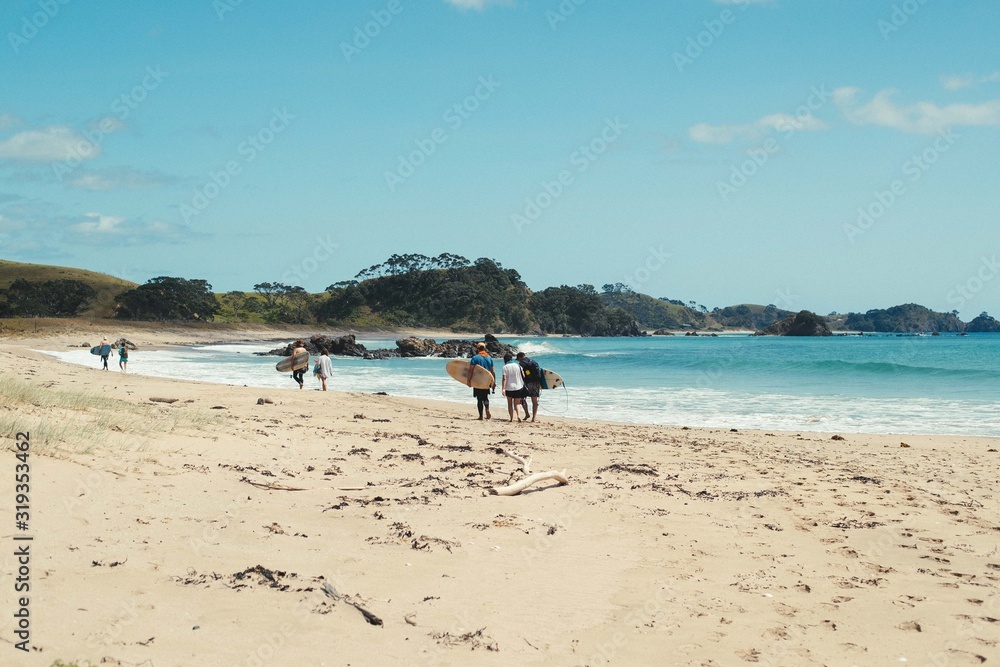 surfers walk around a remote beach to get to the waves surfers walk around a remote beach to get to the waves