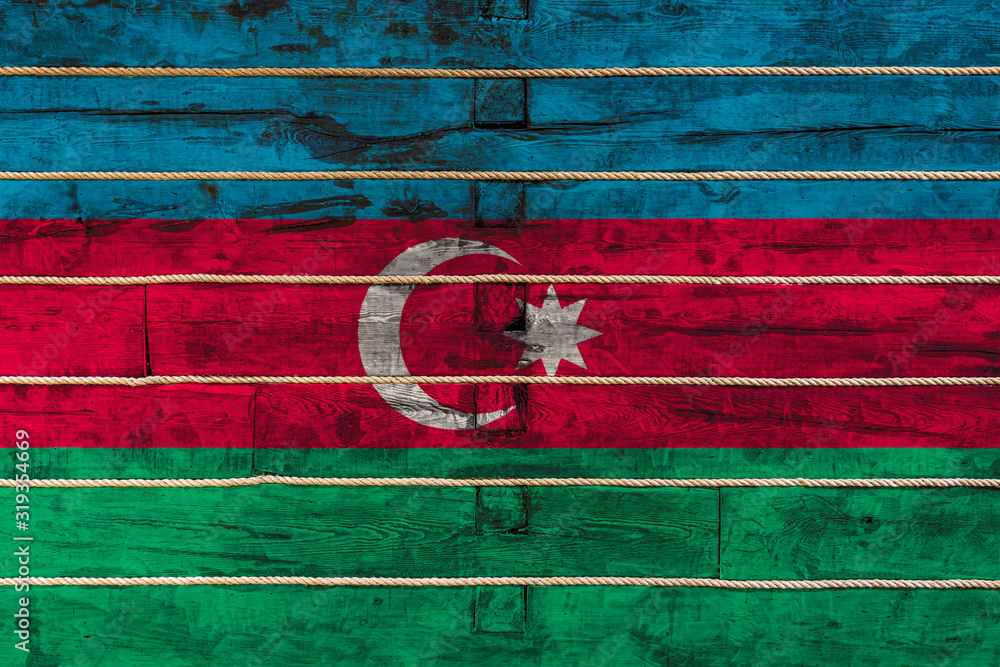 National flag  of Azerbaijan on a wooden wall background. The concept of national pride and a symbol of the country. Flags painted on a wooden fence with a rope