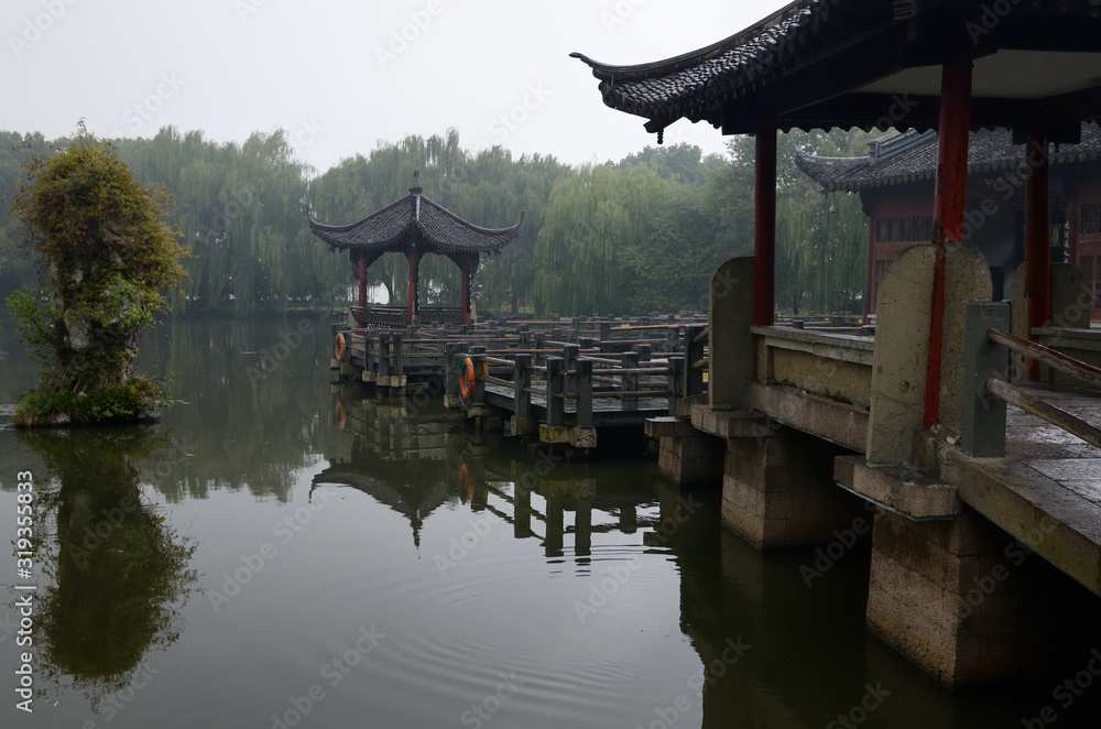 Gazebo walkway and stone pillar at Three Pools Mirroring the Moon Island in West lake Hangzhou China Gazebo walkway and stone pillar at Three Pools Mirroring the Moon Island in West lake Hangzhou China