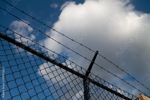 Wallpaper Mural barbed wire silhouette fence with blue sky and white clouds Torontodigital.ca