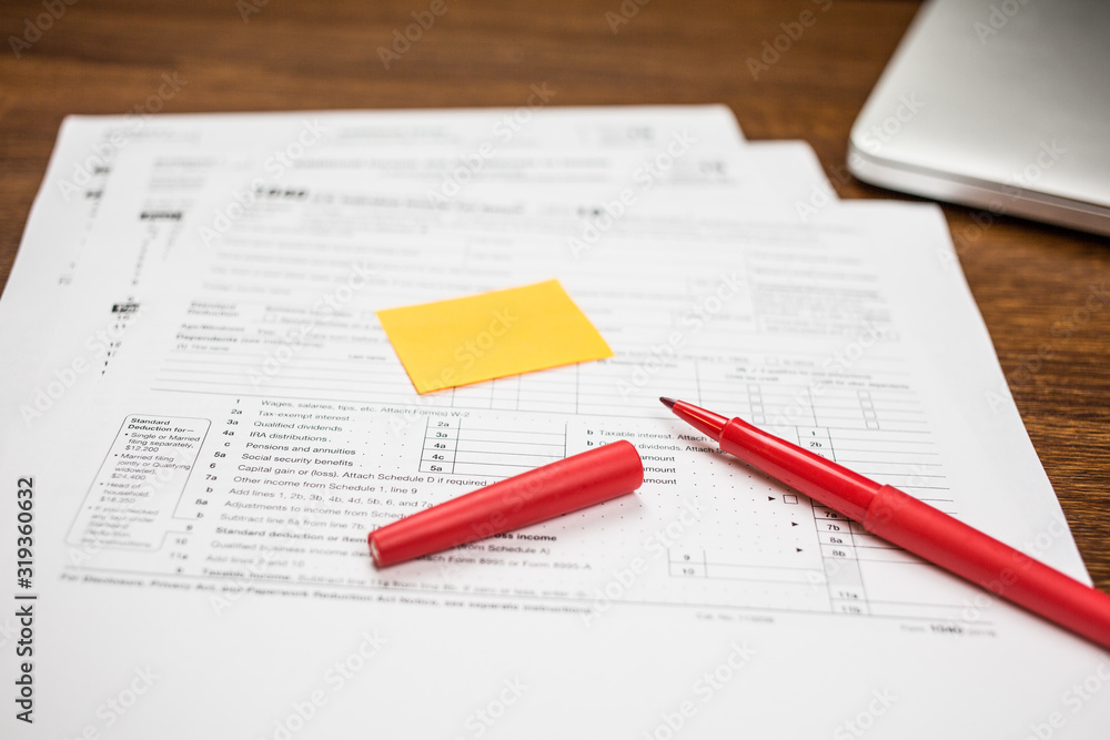 The pen and sticky note are on the tax form 1040 U.S. Individual Income Tax Return. The time to pay taxes. Business concept. The pen and sticky note are on the tax form 1040 U.S. Individual Income Tax Return. The time to pay taxes. Business concept.