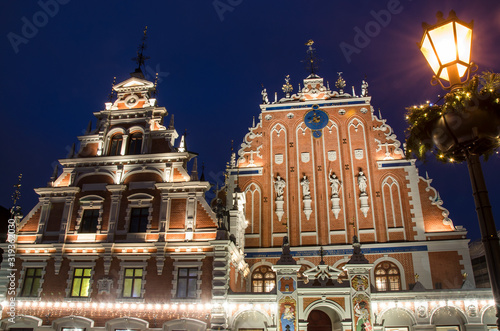 View of famous House of the Black Heads illuminated at night and lantern with Christmas decoration, Riga, Latvia