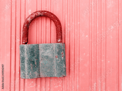 Old locked rustic lock on a pink wooden wall. Saveguard access concept photo