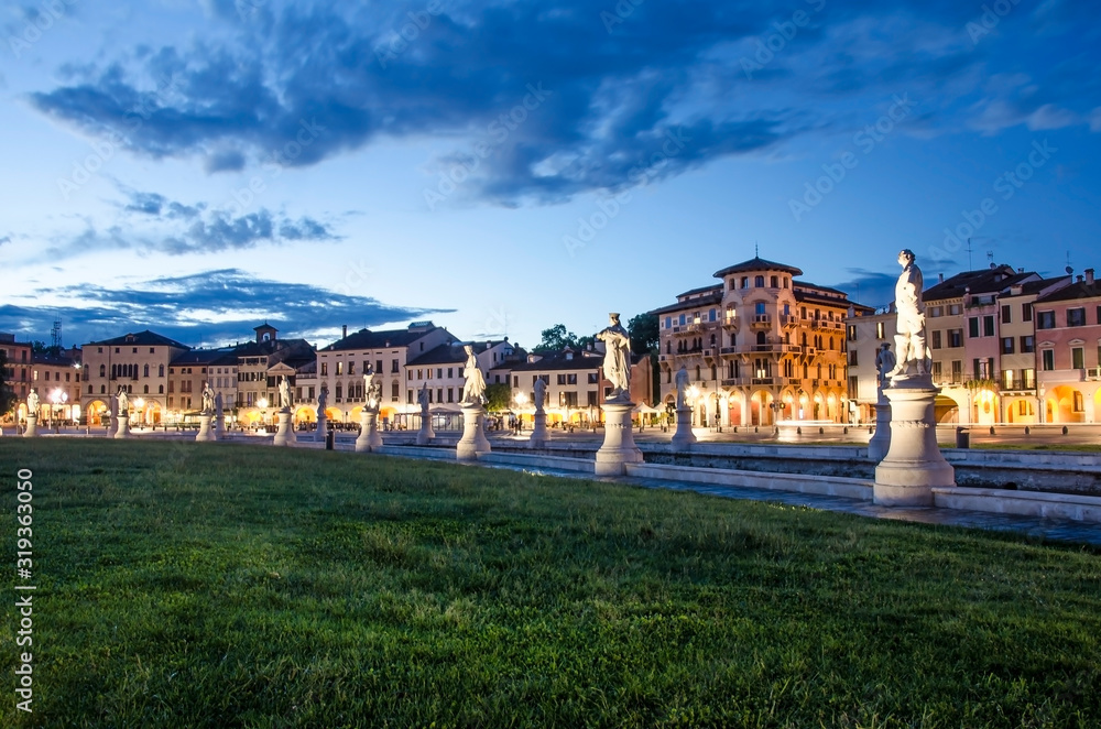 View of the canal with statues on square of Prato della Valle in Padova after sunset, Italy