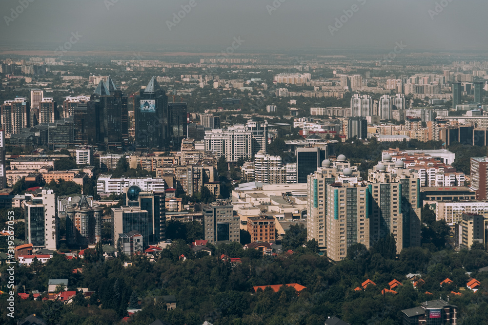 Kazakhstan. View of the city of Almaty. Summer, sunny weather. Tall buildings on a background of mountains