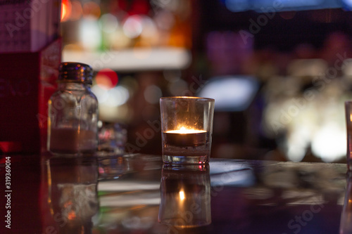 solitary candle slowly burning at a bar