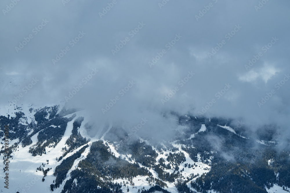 The image of the ski slopes covered by snow clouds.