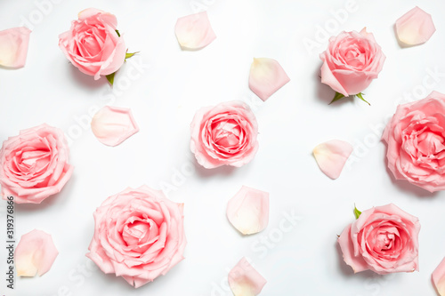 Top view light pastel pink rose flowers and petals composition on white background.Pattern made of roses and petal.