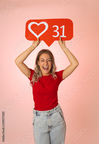 Young woman holding heart social media icon happy. Like and Love social network notifications