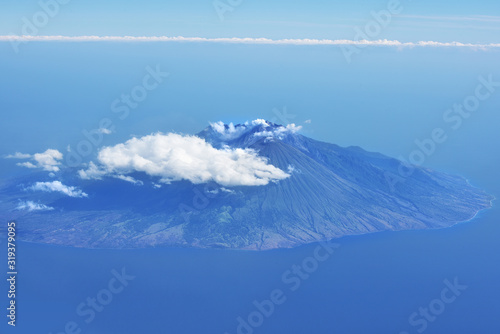 Aerial view of volcanic island surounded by clouds. Indonesia photo