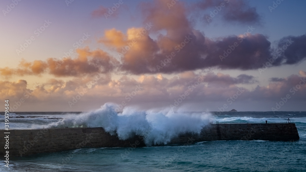 Waves crash onto the quay at Sennen Cove, Cornwall