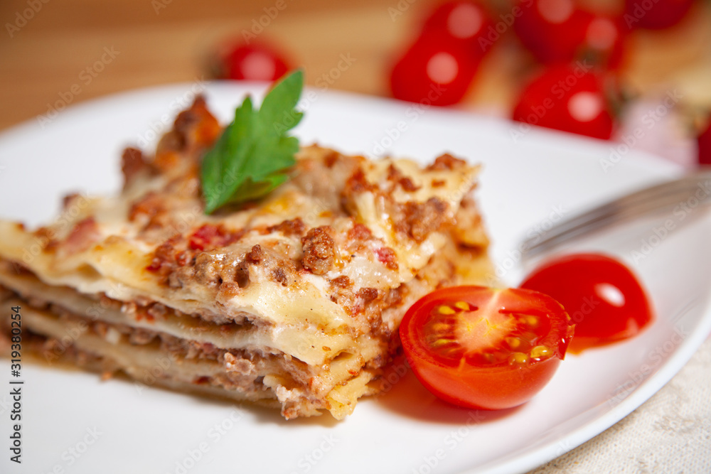 Portion of tasty italian lasagne served on white plate