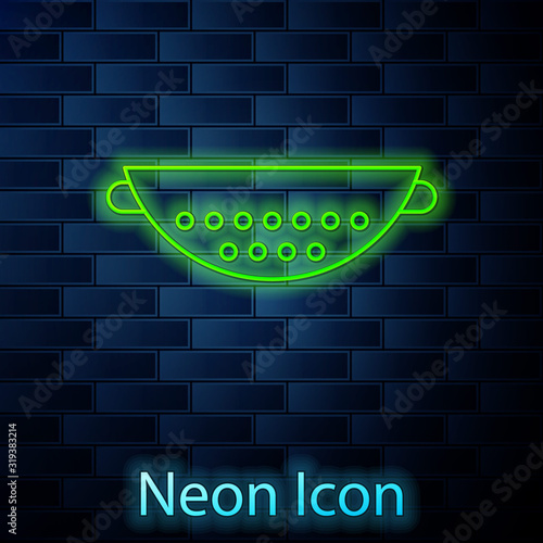 Glowing neon line Kitchen colander icon isolated on brick wall background. Cooking utensil. Cutlery sign. Vector Illustration