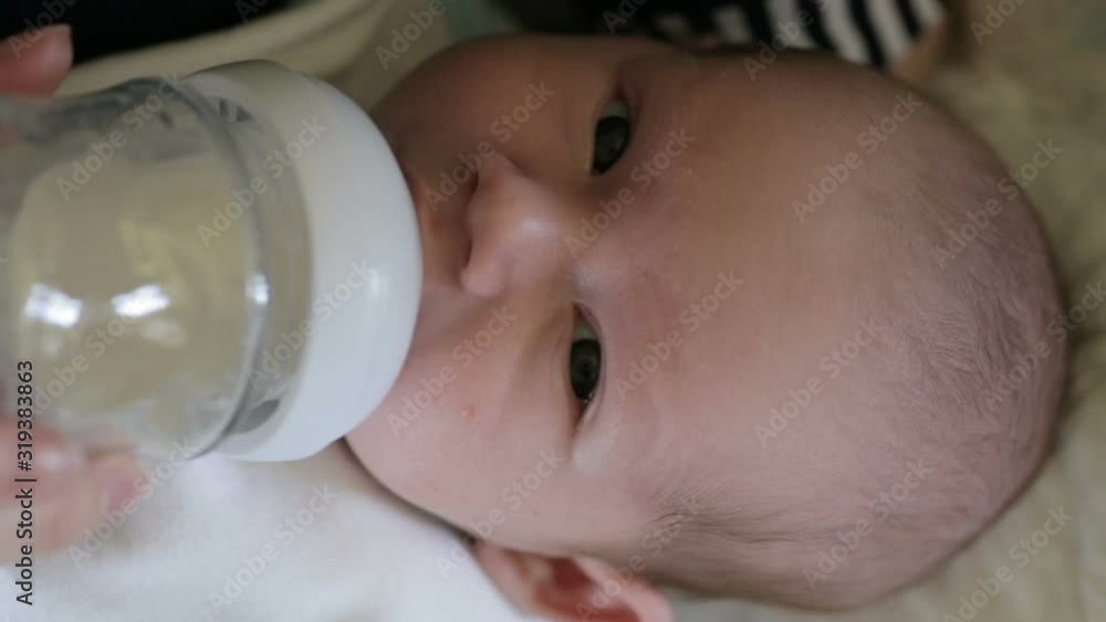 Little infant baby lying on mothers hand drinking milk from bottle. Baby food. Mom and child. Little infant baby lying on mothers hand drinking milk from bottle. Baby food. Mom and child.
