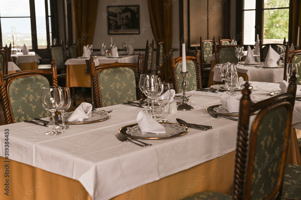 Interior of a classic restaurant in an old castle. Traveling in Europe. Served tables and antiquity Interior of a classic restaurant in an old castle. Traveling in Europe. Served tables and antiquity