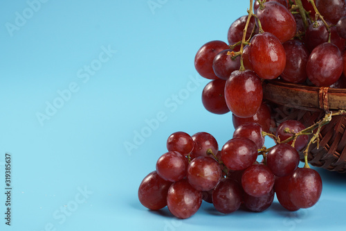 Close up on fresh grape in an old buskets on blue background with copyspace.