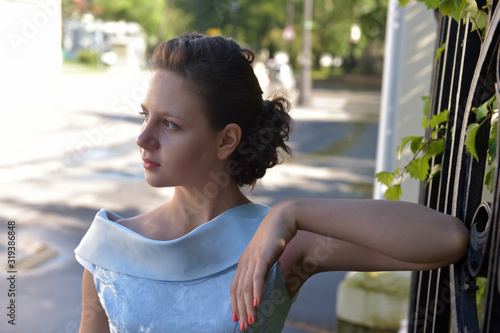 Beautiful brunette in pale blue evening dress outdoor. photo