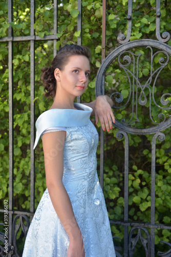 Beautiful brunette in pale blue evening dress outdoor. photo