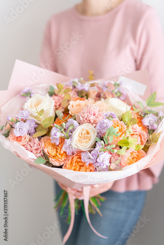 Beautiful bouquet of mixed flowers in womans hands. the work of the florist at a flower shop. Handsome fresh bouquet. Flowers delivery
