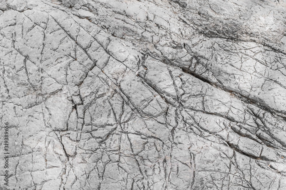 Texture of gray stone covered with small cracks.