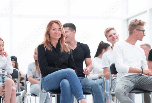 young woman sitting among the listeners of the business seminar © ASDF