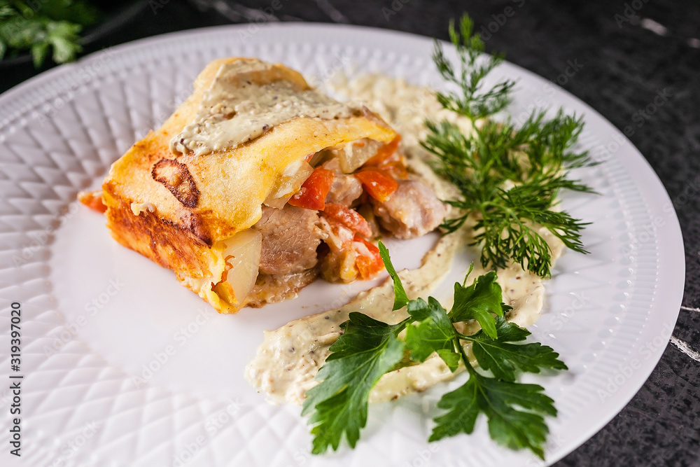 Potato casserole with meat and vegetables, parsley, dill and sauce. Tasty and healthy food. Close up Potato casserole with meat and vegetables, parsley, dill and sauce. Tasty and healthy food. Close up