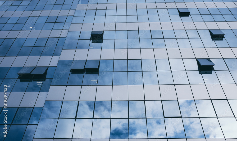 View of blue windows in a skyscraper modern offices building - concept of people at work at life - openand close windows with sky reflection View of blue windows in a skyscraper modern offices building - concept of people at work at life - openand close windows with sky reflection