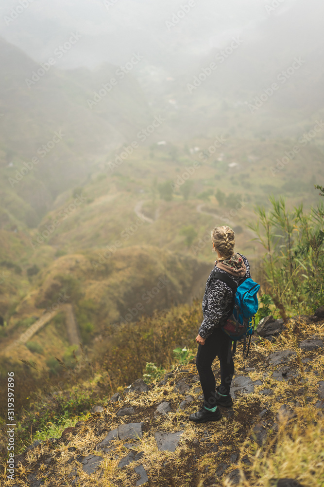 Naklejka premium Santo Antao Island Cape Verde. Female tourist with backpack enjoying hiking path route to Paul valley