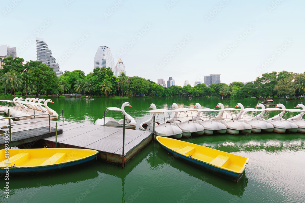White duck boat pedal or Paddle goose boat in the lake, Anonymous people spend some time relaxing with family, couples in the park,Lumphini public park,Bangkok,Thailand