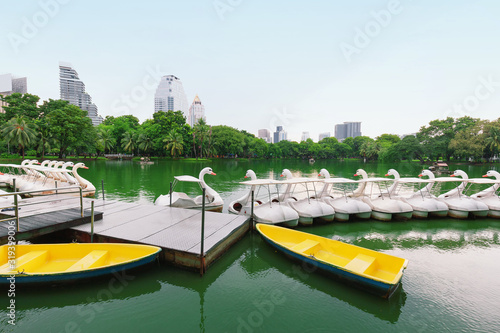 White duck boat pedal or Paddle goose boat in the lake, Anonymous people spend some time relaxing with family, couples in the park,Lumphini public park,Bangkok,Thailand