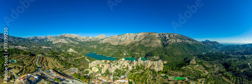 Panoramic view of popular Spanish vacation destination El Castell de Guadalest above a beautiful water reservoir with 2 castles and fortified enclave © tamas