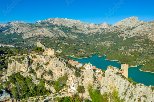 Panoramic view of popular Spanish vacation destination El Castell de Guadalest above a beautiful water reservoir with 2 castles and fortified enclave