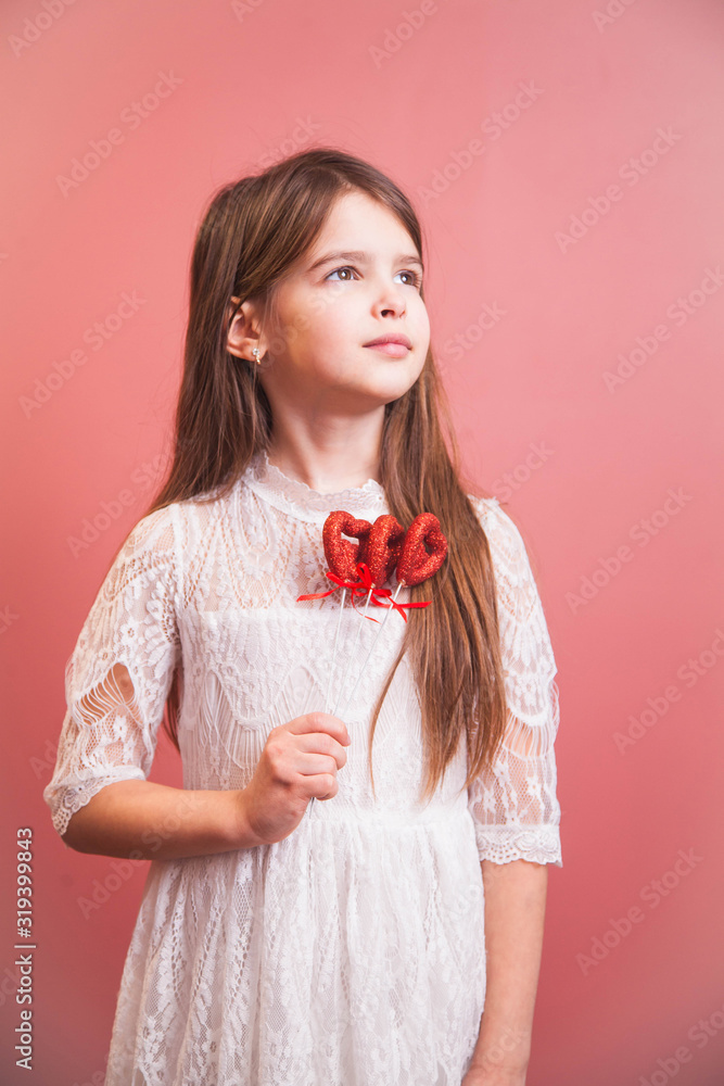 a beautiful girl in a white dress playfully poses on a pink background a beautiful girl in a white dress playfully poses on a pink background