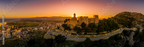 Fotografiet Cullera castle and church on a hilltop overlooking the popular summer resort tow