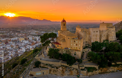 Aerial sunset view of Cullera castle and Sanctuary of the Virgen del Castillo above the popular summer resort vacation beach town near Valencia Spain