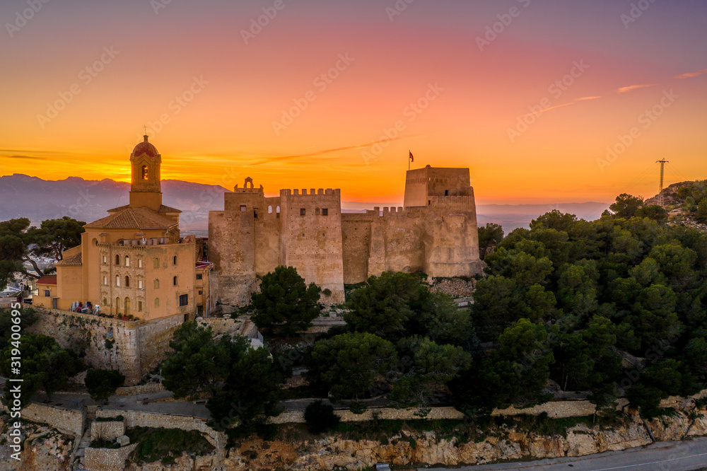 Aerial sunset view of Cullera castle and Sanctuary of the Virgen del Castillo above the popular summer resort vacation beach town near Valencia Spain