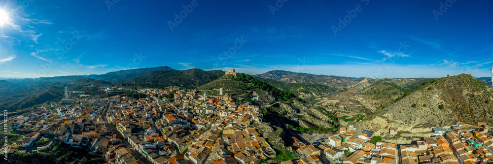 Panoramic aerial view of the ruined castle structure of medieval Gothic Jalance castle near Cofrentes Spain with the town of Jalance
