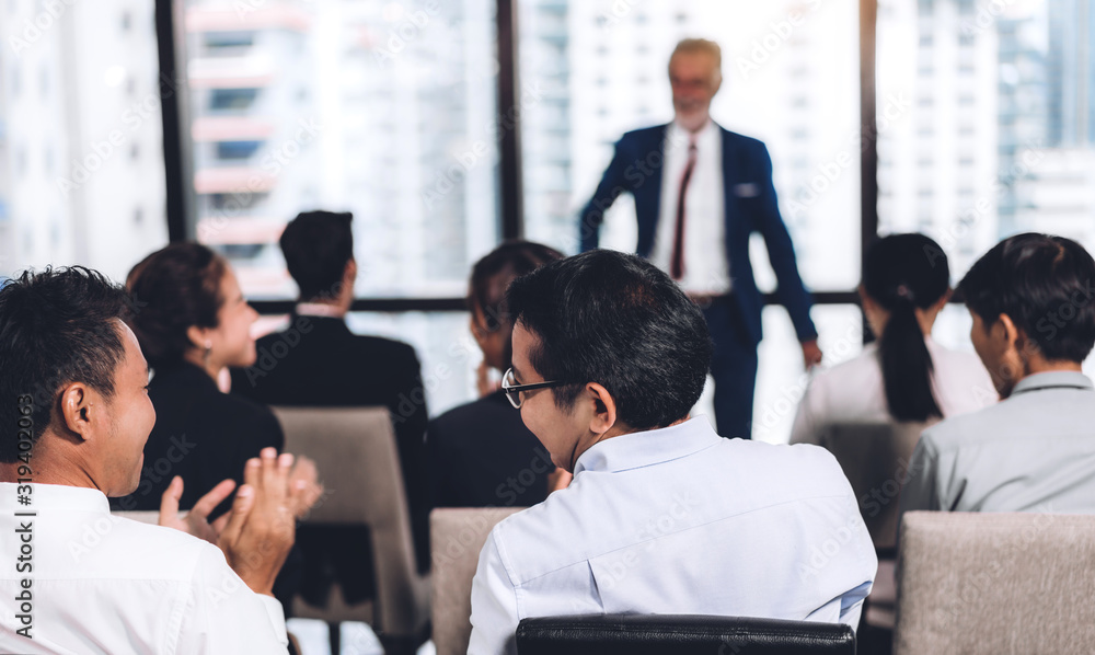 Businessman standing in front of group of people in consulting meeting conference seminar at hall or seminar room.presentation and coaching concept Businessman standing in front of group of people in consulting meeting conference seminar at hall or seminar room.presentation and coaching concept