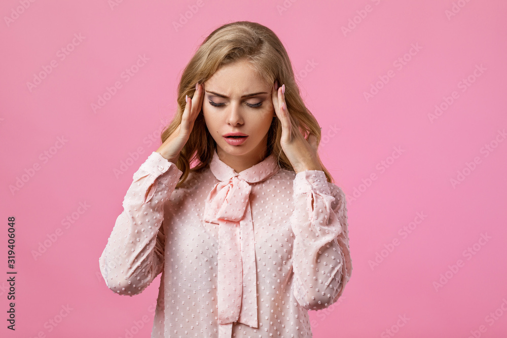 young sad woman feeling stress and headache on pink background. young sad woman feeling stress and headache on pink background.