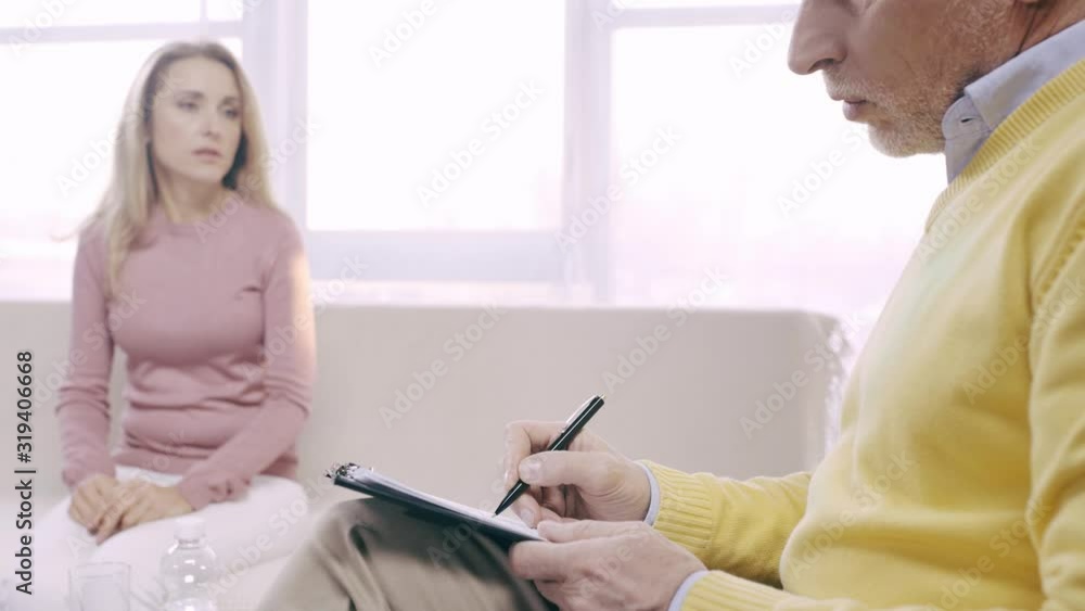 cropped view of mature psychologist writing prescription while talking to patient cropped view of mature psychologist writing prescription while talking to patient