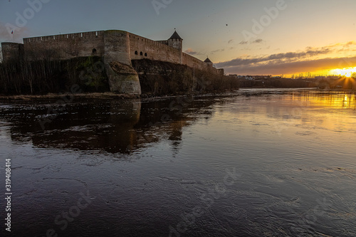 Beautiful river embankment overlooking the medieval castle and the fortress wall. Walk in the early morning in winter