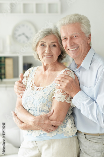 Portrait of cheerful senior couple embracing at home